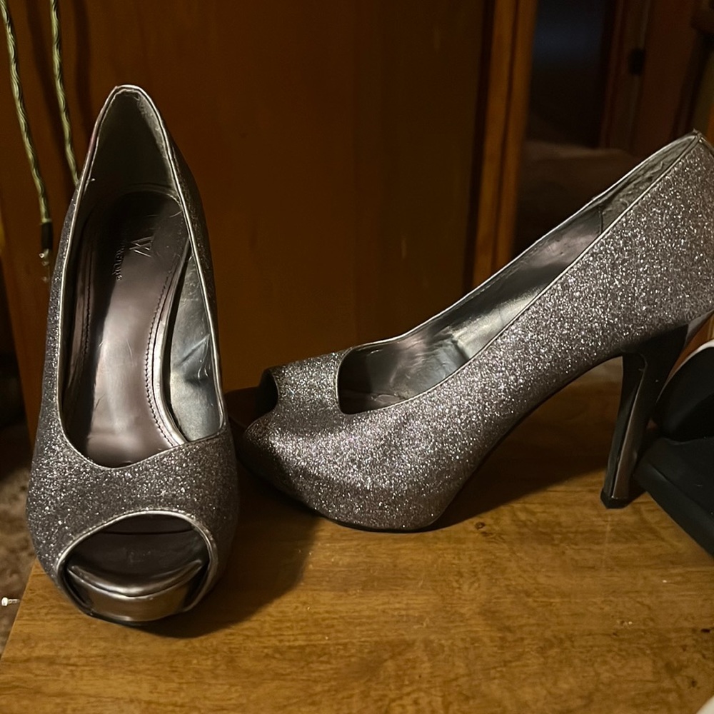 Heels , worn a few times , has a chip on the left shoe .